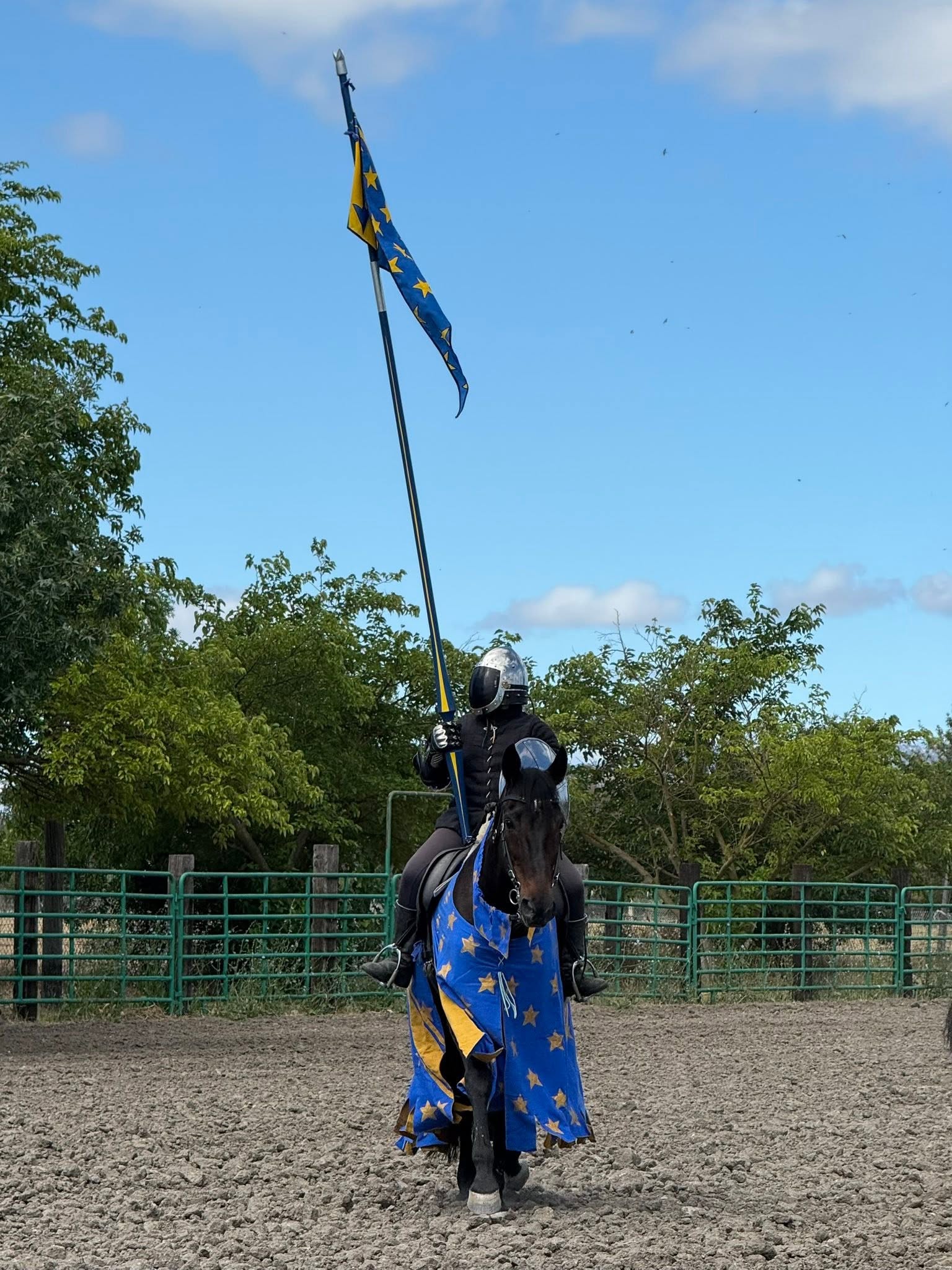 Woman atop a horse accoutered and caparisoned with a lance and banner